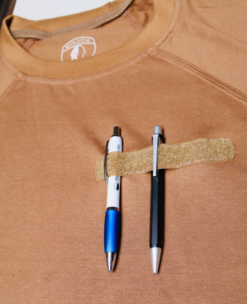 Two pens attached to a brown shirt with Security Badge velcro tape.