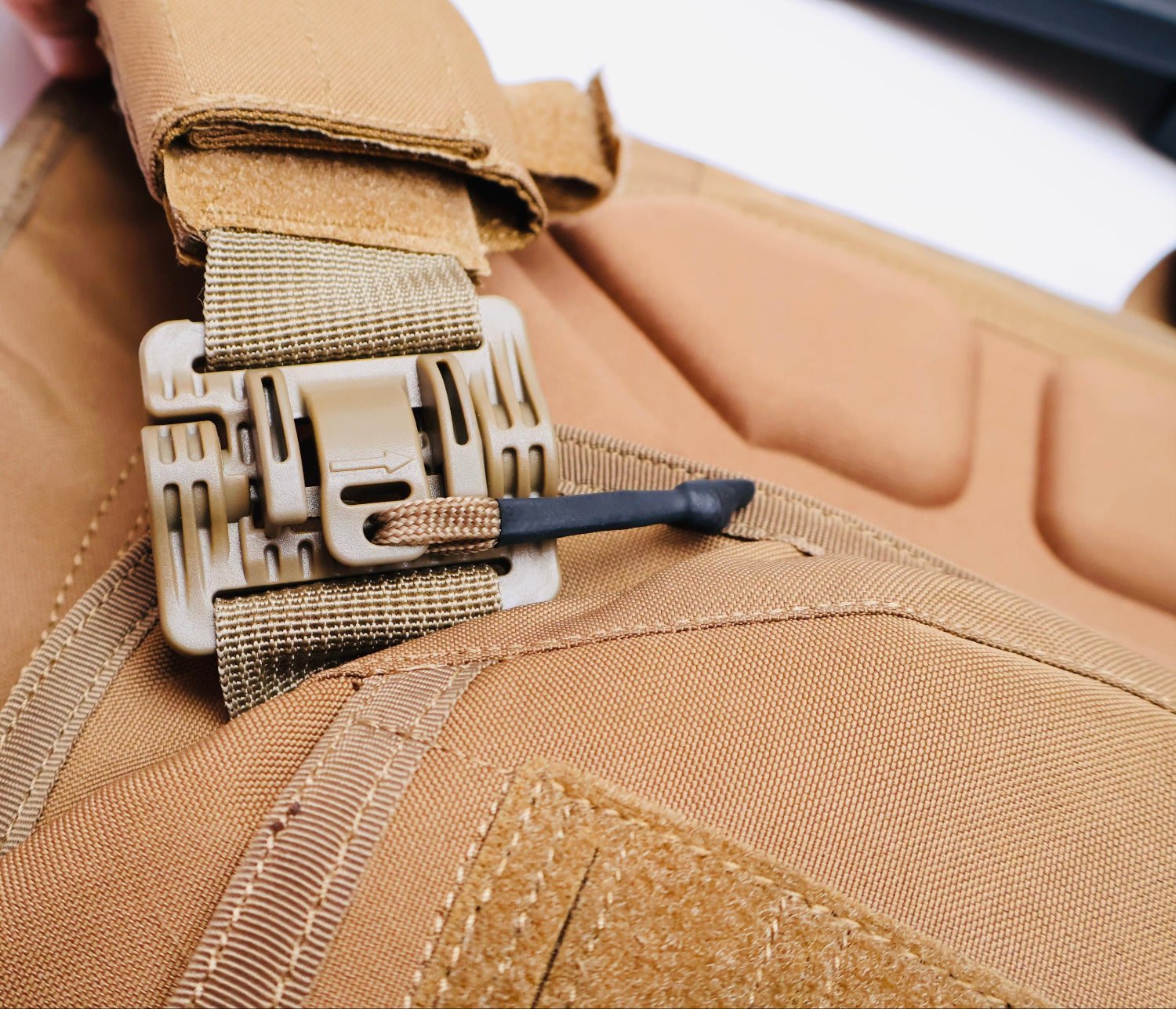 Close-up of a tan tactical belt with a buckle on a matching brown background
