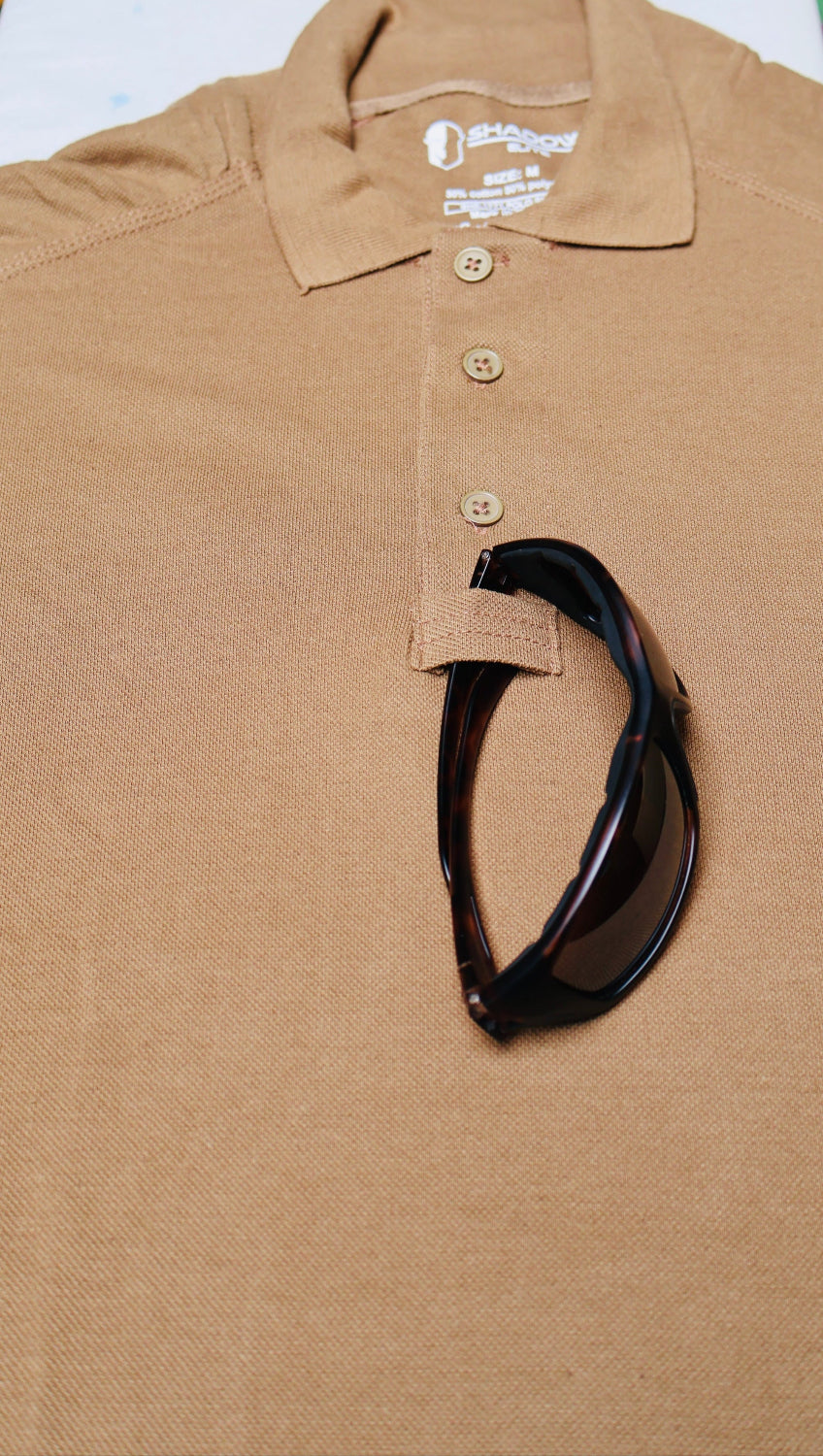 Brown polo shirt with sunglasses on a white surface