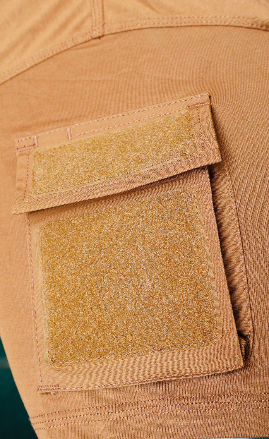 Close-up of a brown tactical patch on a similar brown fabric background