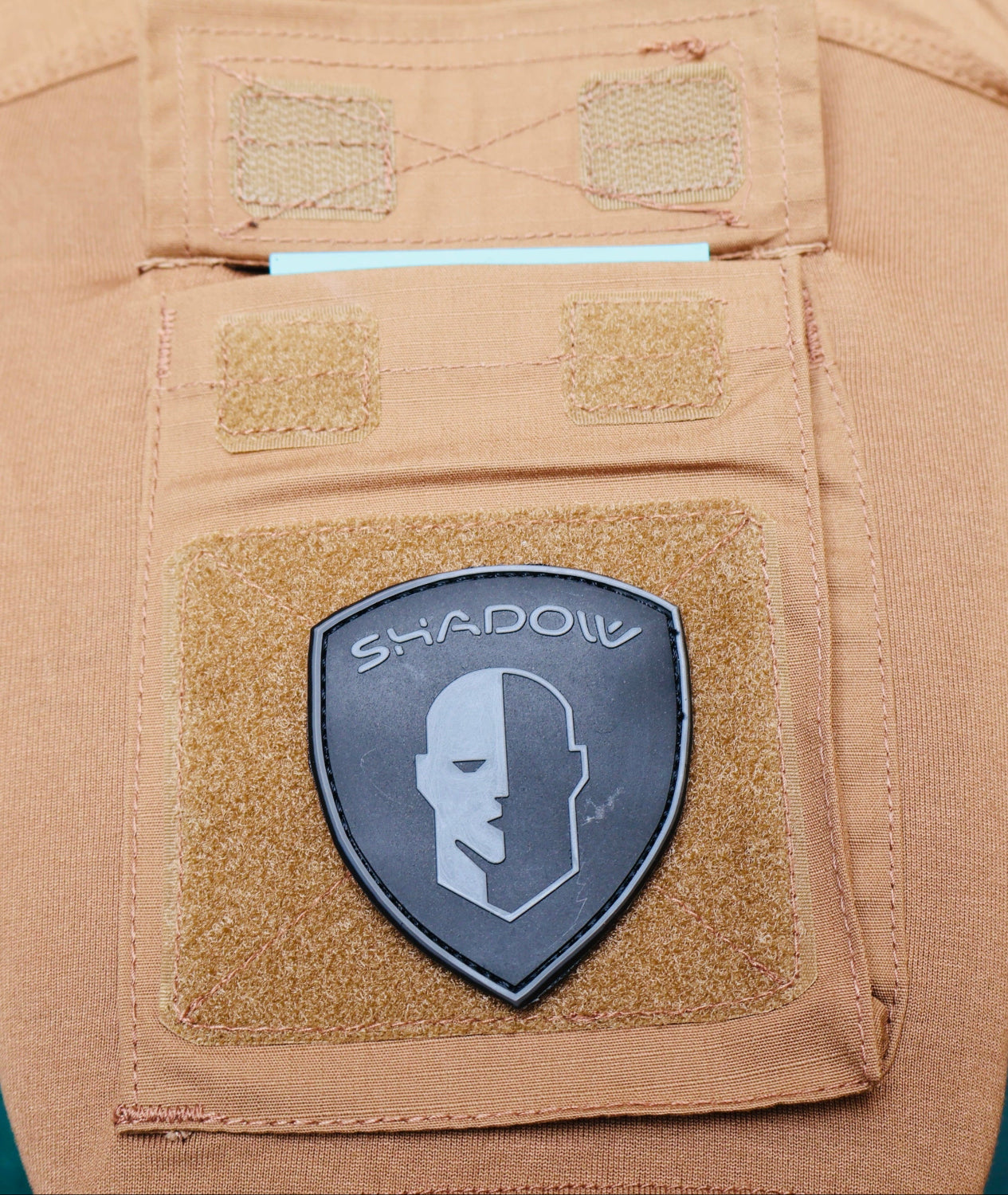 Tan pants with a 'Shadow' patch on a blurred background