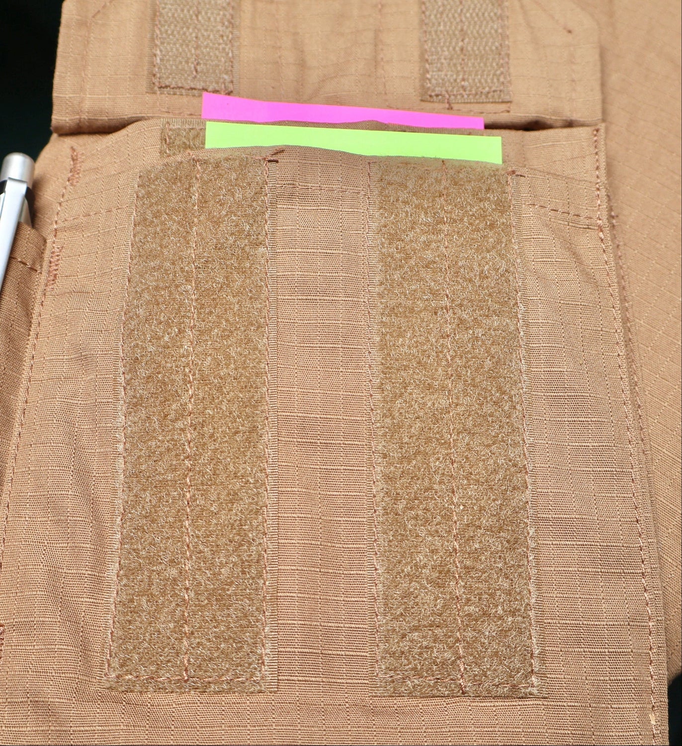 Close-up of a brown tactical vest with a zipper and fabric texture.