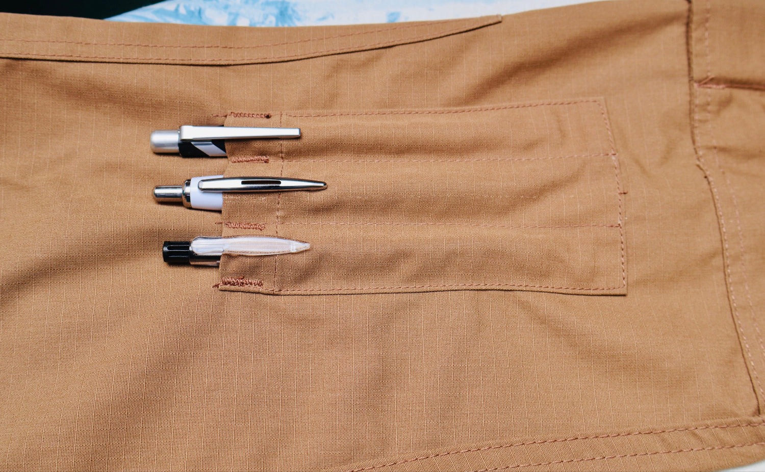 Three drill bits on a brown fabric surface