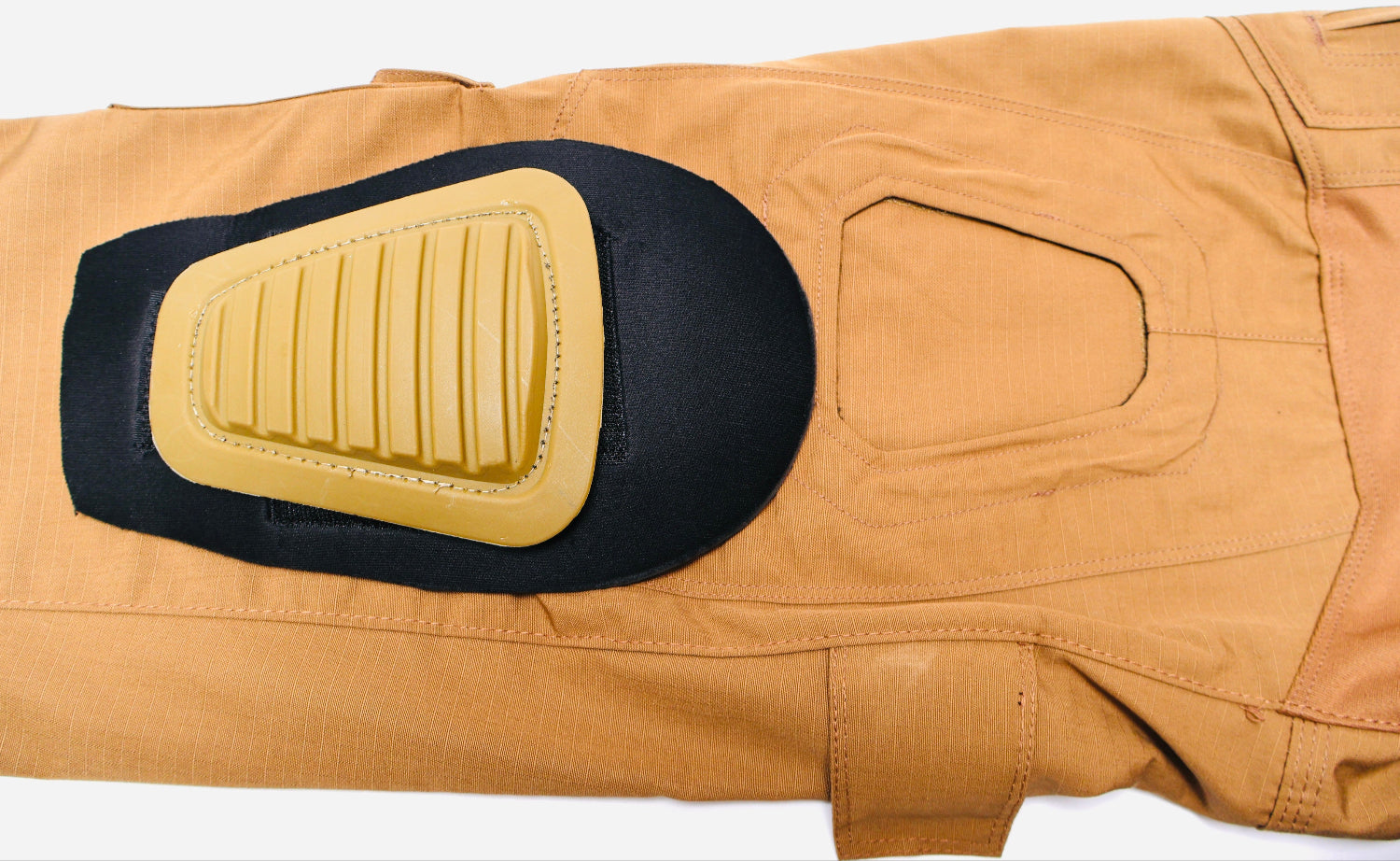 Tan pants with a black and yellow knee pad on a white background